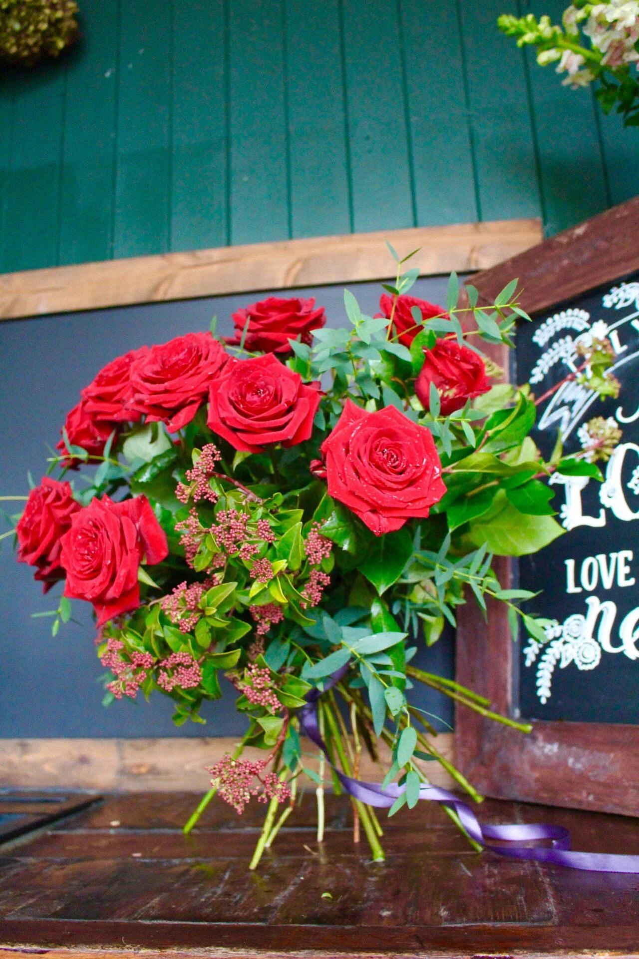 The classic dozen red roses - beautiful, bright red roses in full bloom with plenty of luscious foliage and a sprinkling of tiny flowers for a meadowy feel - perfect for Valentines and other romantic dates.