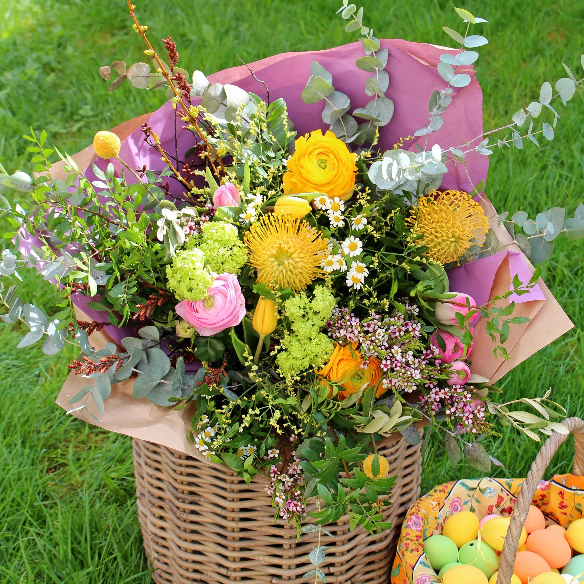 Beautiful spring themed floral bouquet featuring large, bright yellow and pink blooms mixed with cute little meadow flowers and lots of lush greenery.
